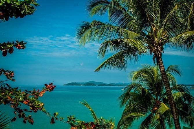 A view of islands through some palm trees on Port Barton beach. Palawan itinerary