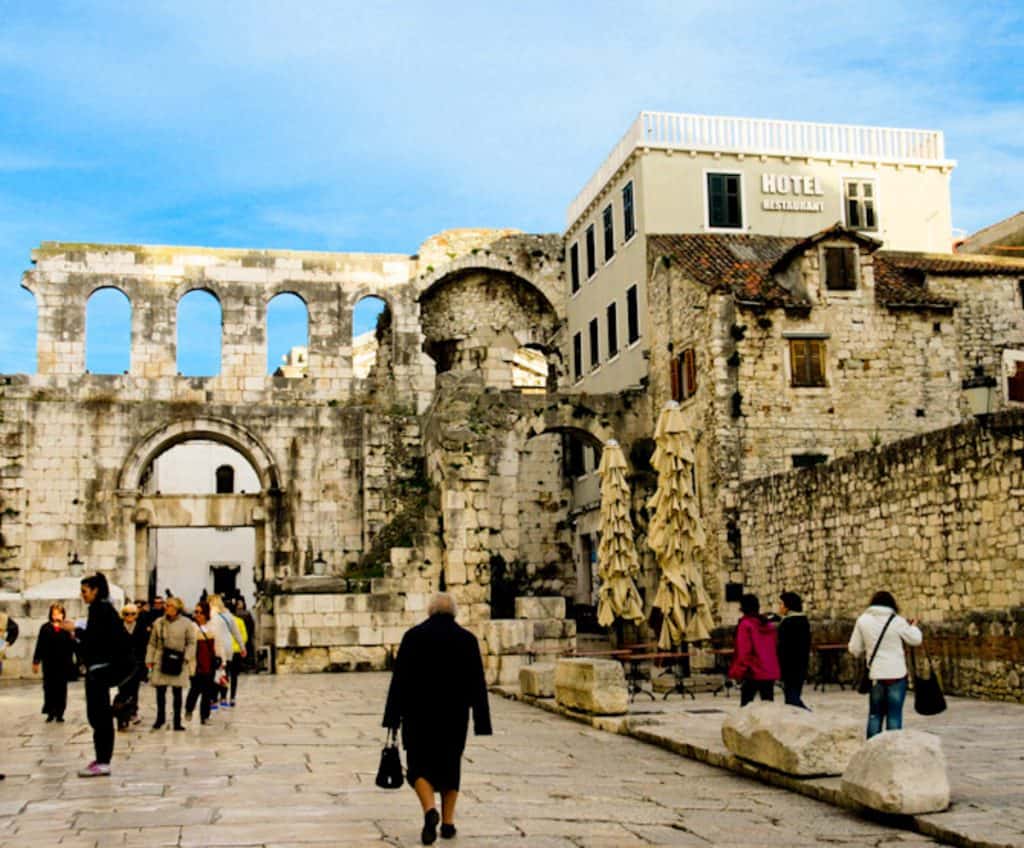An elderly lady dressed in black walking the cobblestone streets of Diocletian's Palace. Posted in Split vs Dubrovnik article