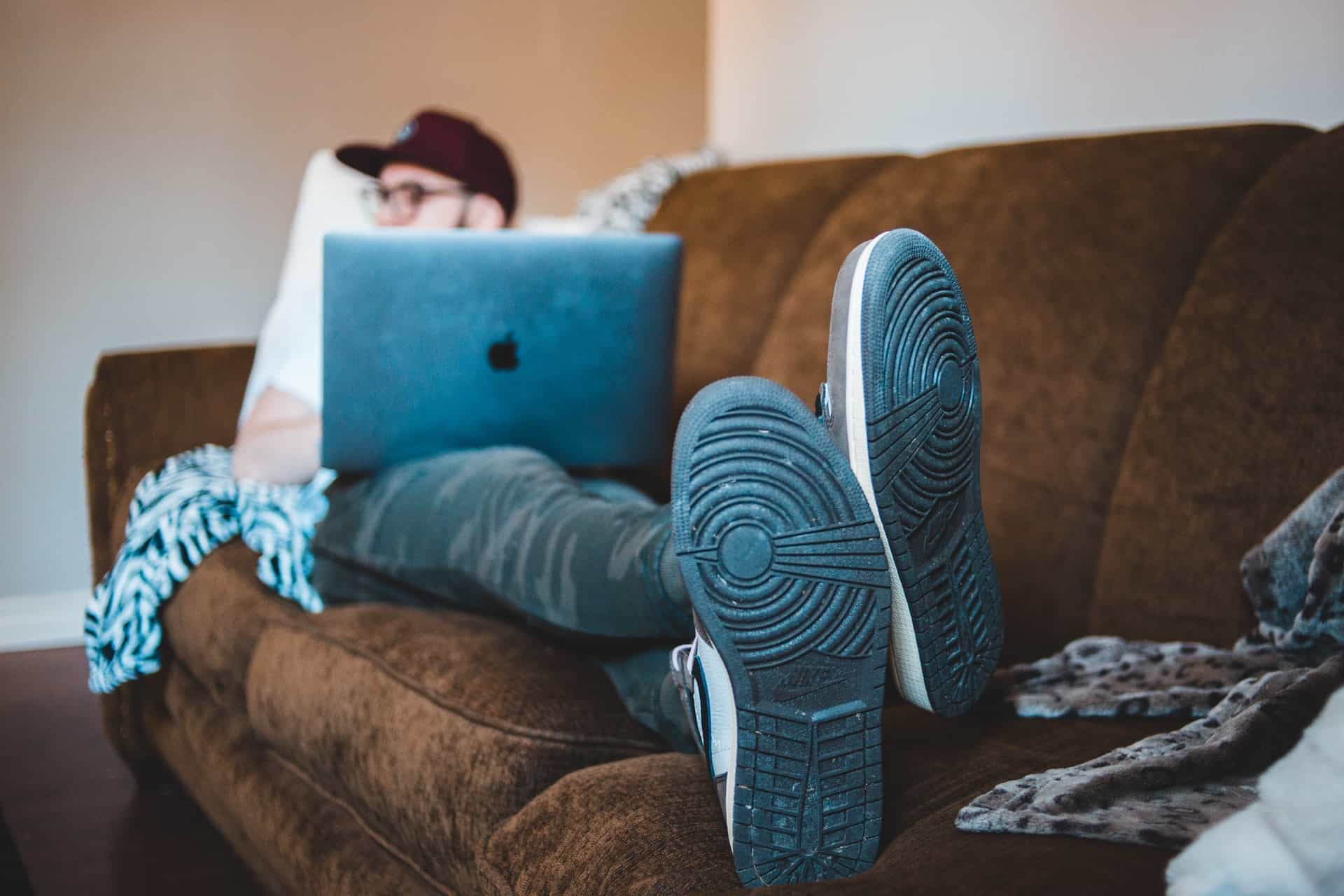 Man laying on couch with laptop