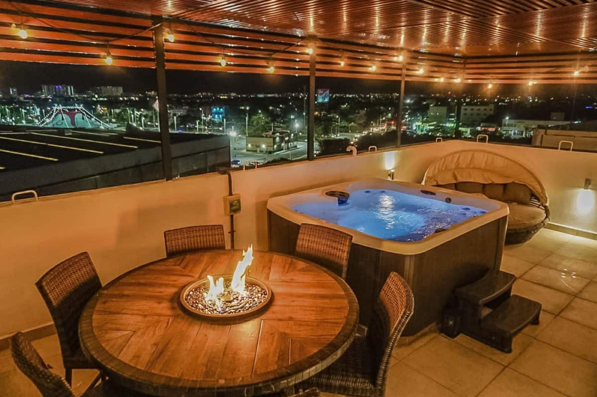 Hot tub and fireplace on rooftop with view of Cancun centro