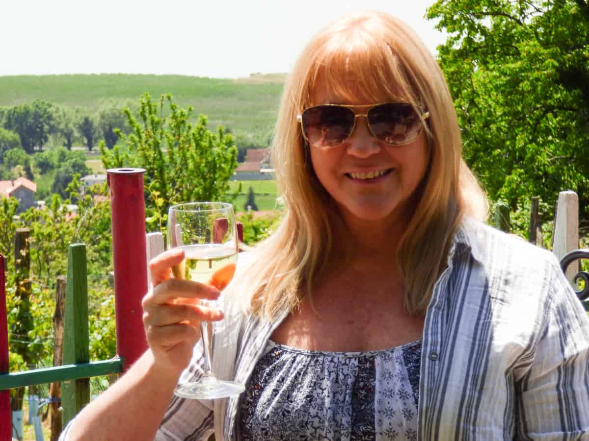 Sarah with a glass of wine and backdrop of vineyards at Lake Balaton Hungary